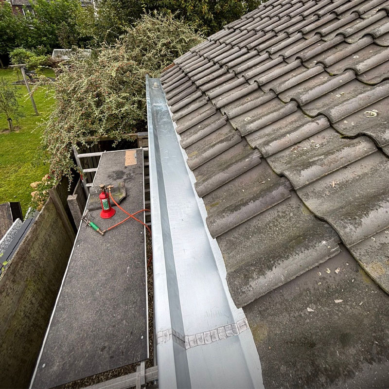 Plaatsen zinken dakgoot